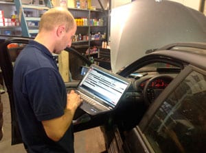 Technicus stelt de boordelektronica bij met een diagnose-laptop.