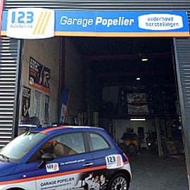De werkplaats van Garage Popelier in Veurne met de poort open.